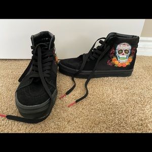 All black vans with sugar skulls on side